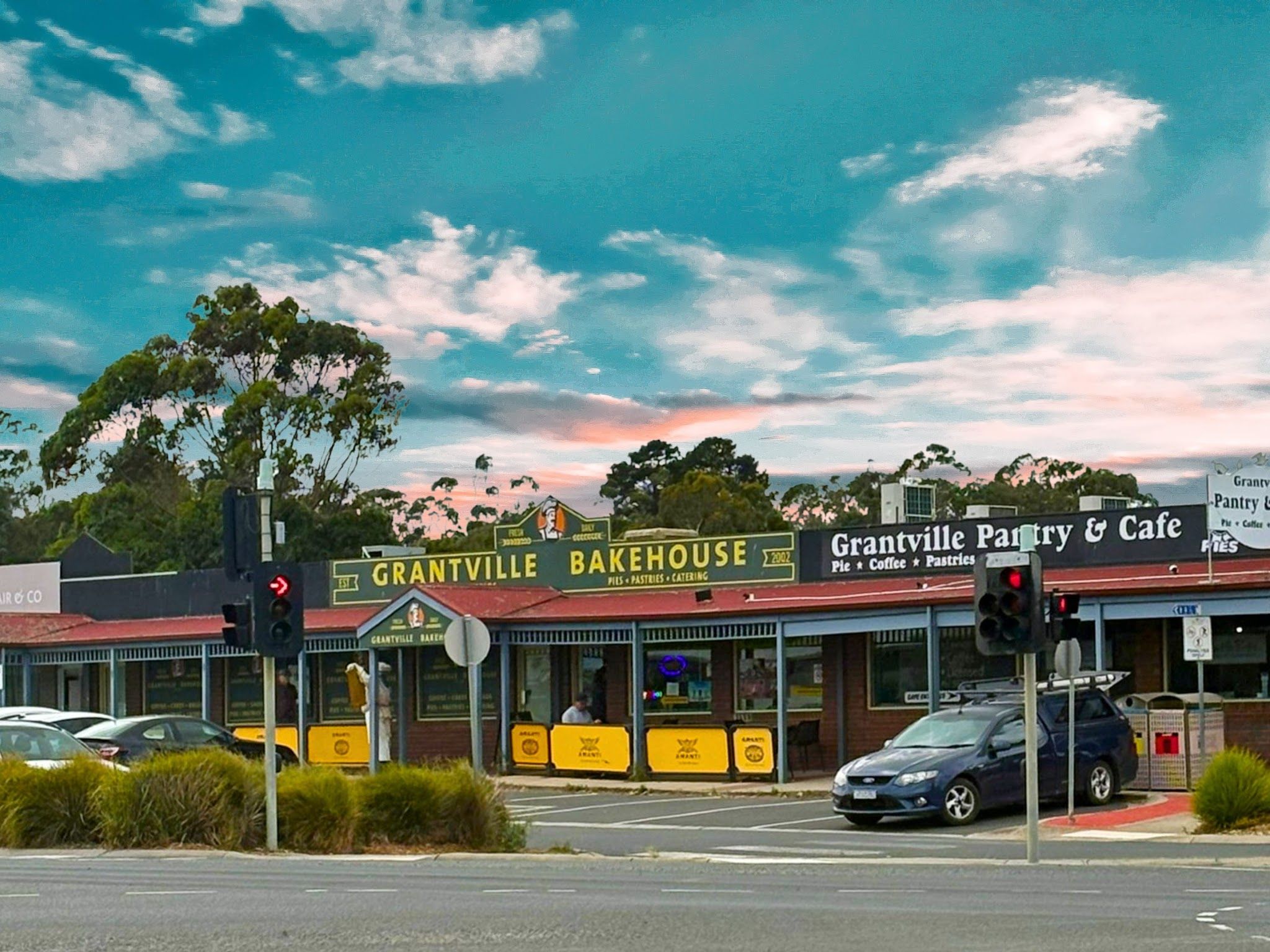 Grantville Bakehouse exterior at dusk with dramatic pink sky and Bass Highway context
