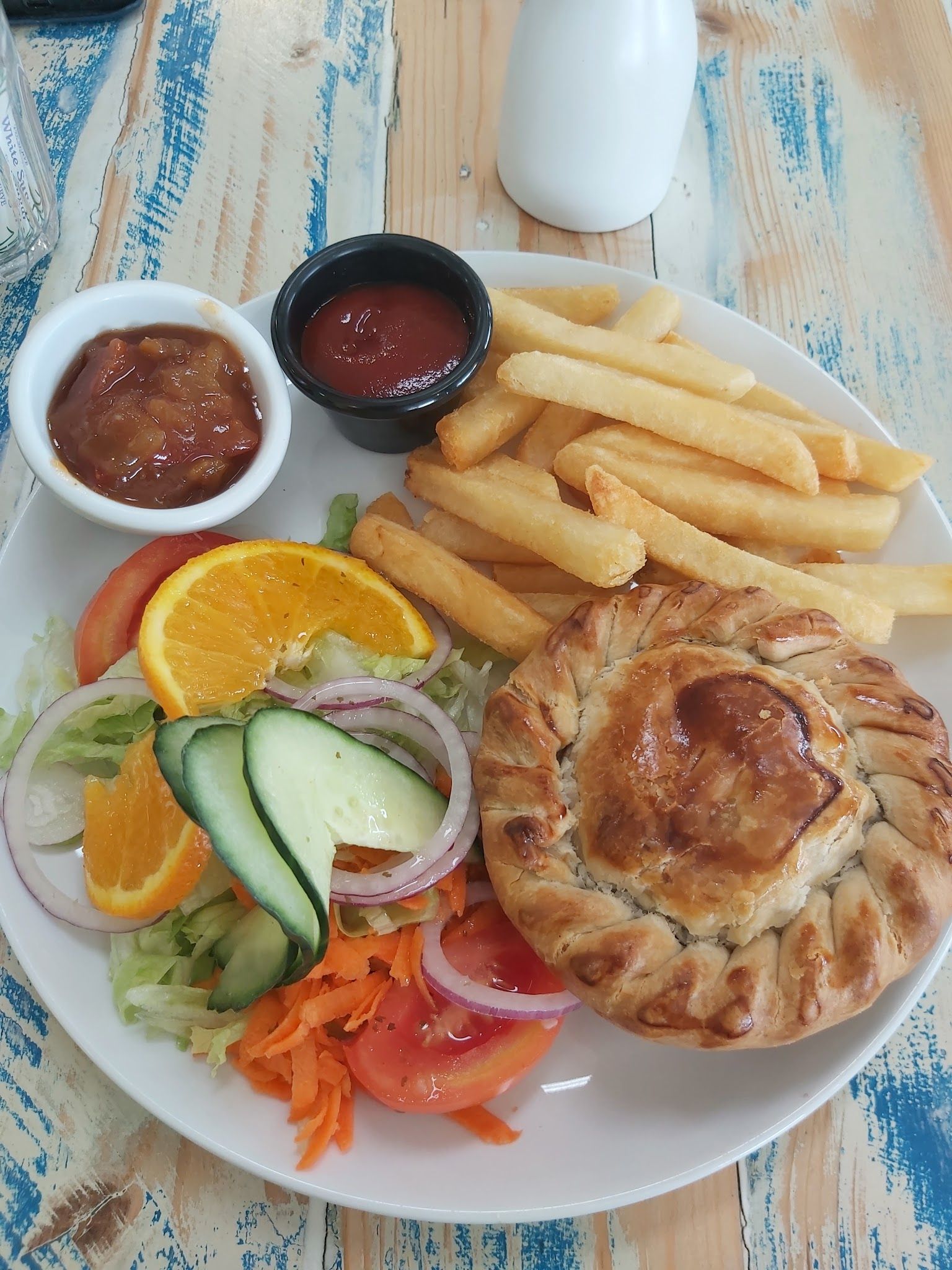 Meat pie with chips, salad and sauce on white plate at Grantville Bakehouse