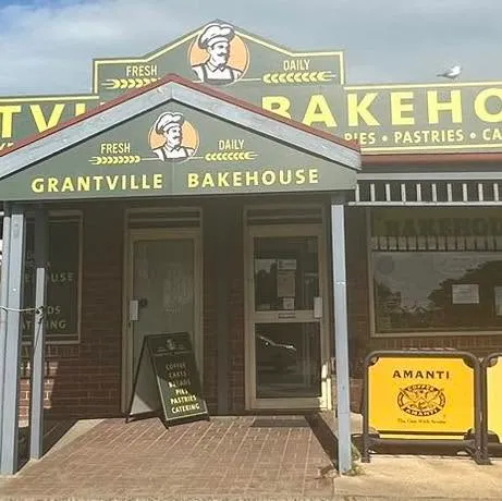 Grantville Bakehouse storefront with green and yellow signage and chef mascot